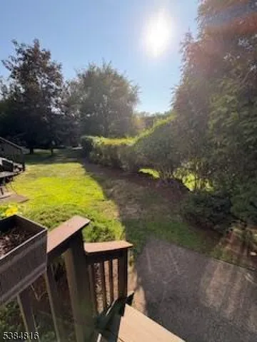 a view of a backyard with lawn chairs under an umbrella