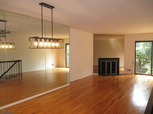 a view of a livingroom with a fireplace wooden floor and chandelier
