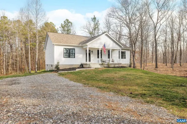 a front view of a house with a yard and trees