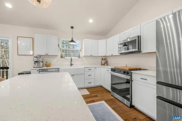 a kitchen with white cabinets and appliances