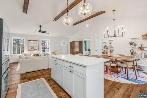 a large white kitchen with sink and chairs