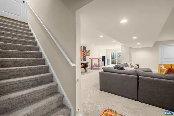 a living room with furniture and stairs
