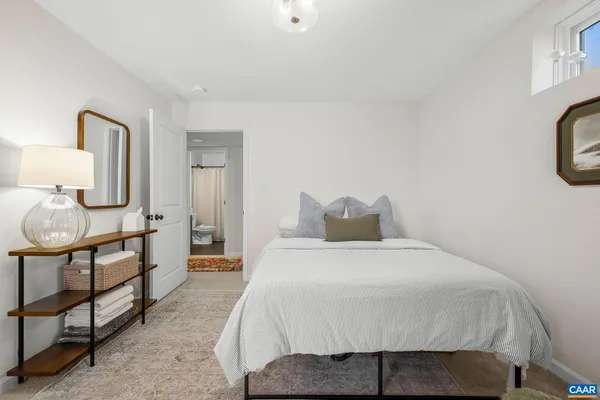 a bedroom with a bed a mirror and lamp