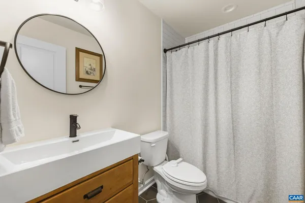a bathroom with a sink a toilet and a mirror