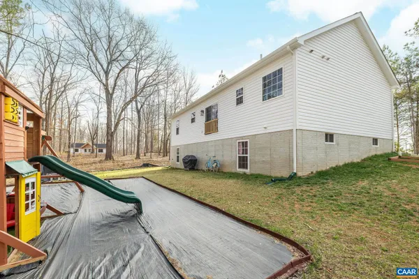 a view of a house with backyard and trees