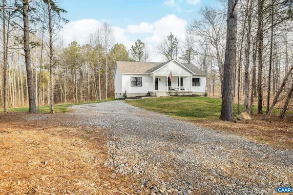 a front view of a house with a yard and trees