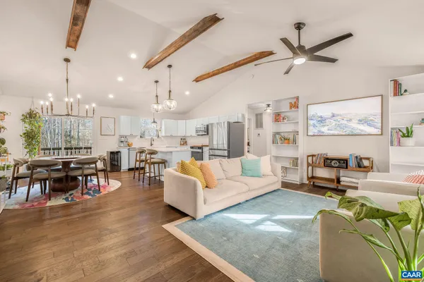 a living room with lots of furniture and a ceiling fan