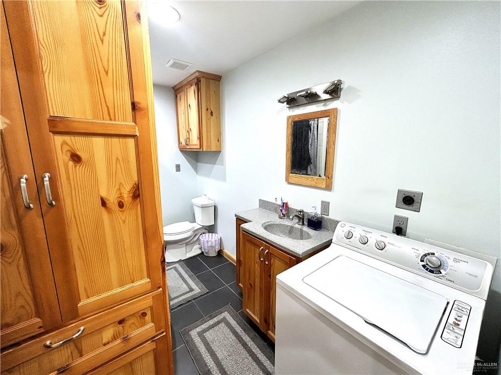 5101 Mile 8 Road Edinburg, TX 78541 - Photo 11 of 18 a bathroom with a sink a toilet and a mirror