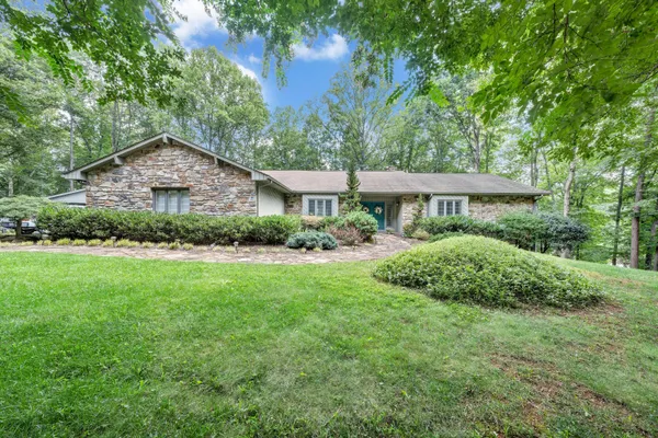 a front view of a house with a yard and trees