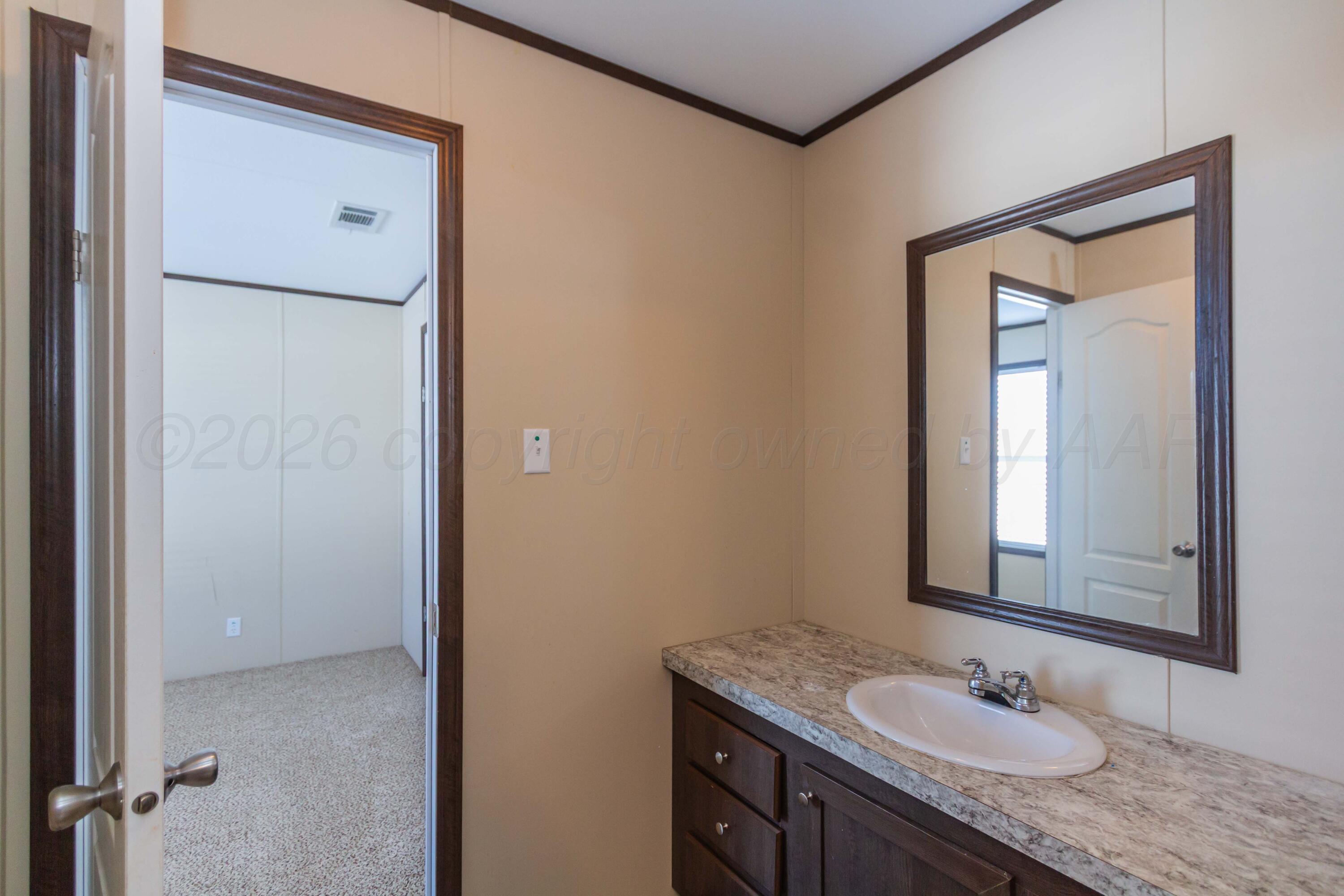 108 North Canadian Street Wheeler, TX 79096 - Photo 26 of 42 a bathroom with a granite countertop sink and a mirror