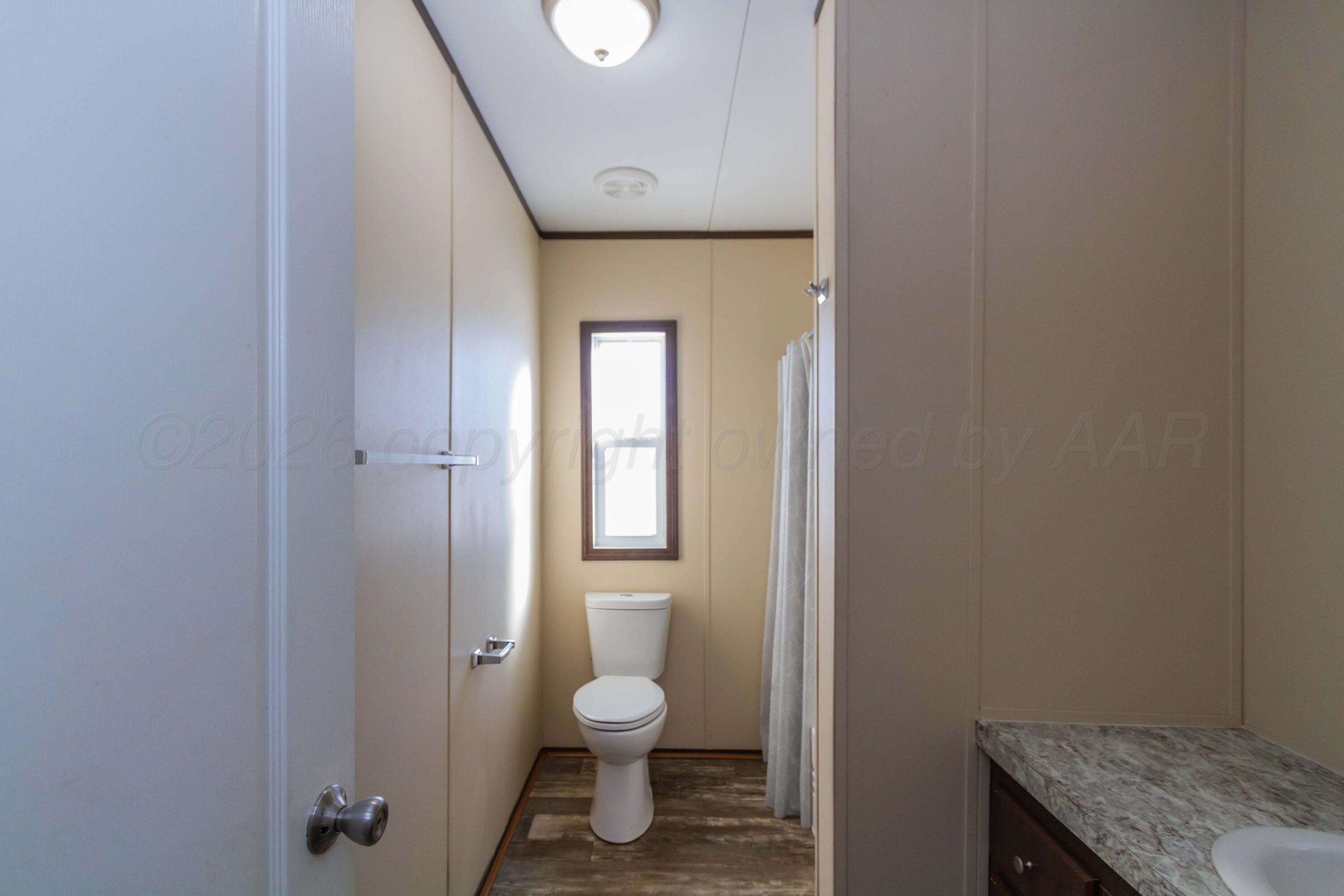 108 North Canadian Street Wheeler, TX 79096 - Photo 33 of 42 a bathroom with a granite countertop toilet and a sink