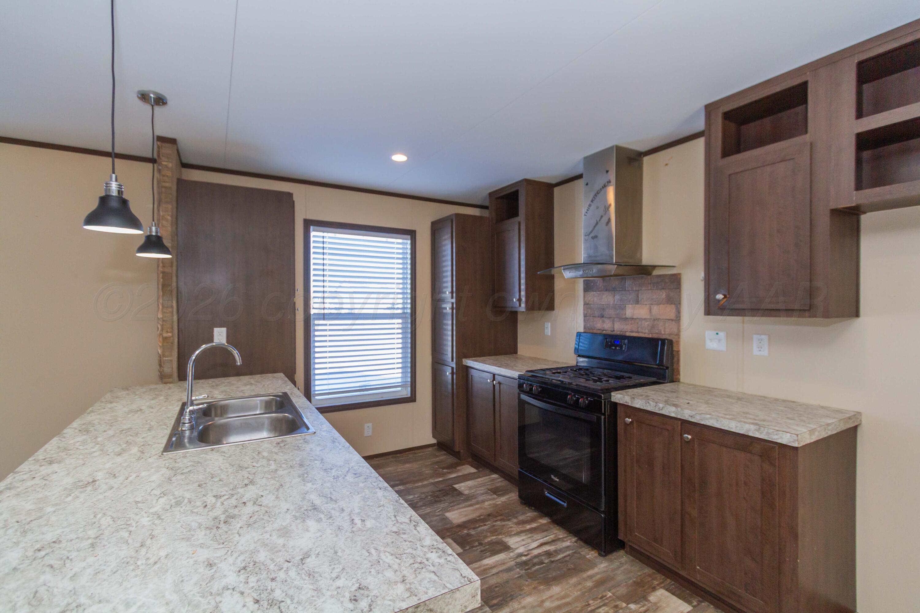 108 North Canadian Street Wheeler, TX 79096 - Photo 8 of 42 a kitchen with granite countertop a sink a stove and refrigerator
