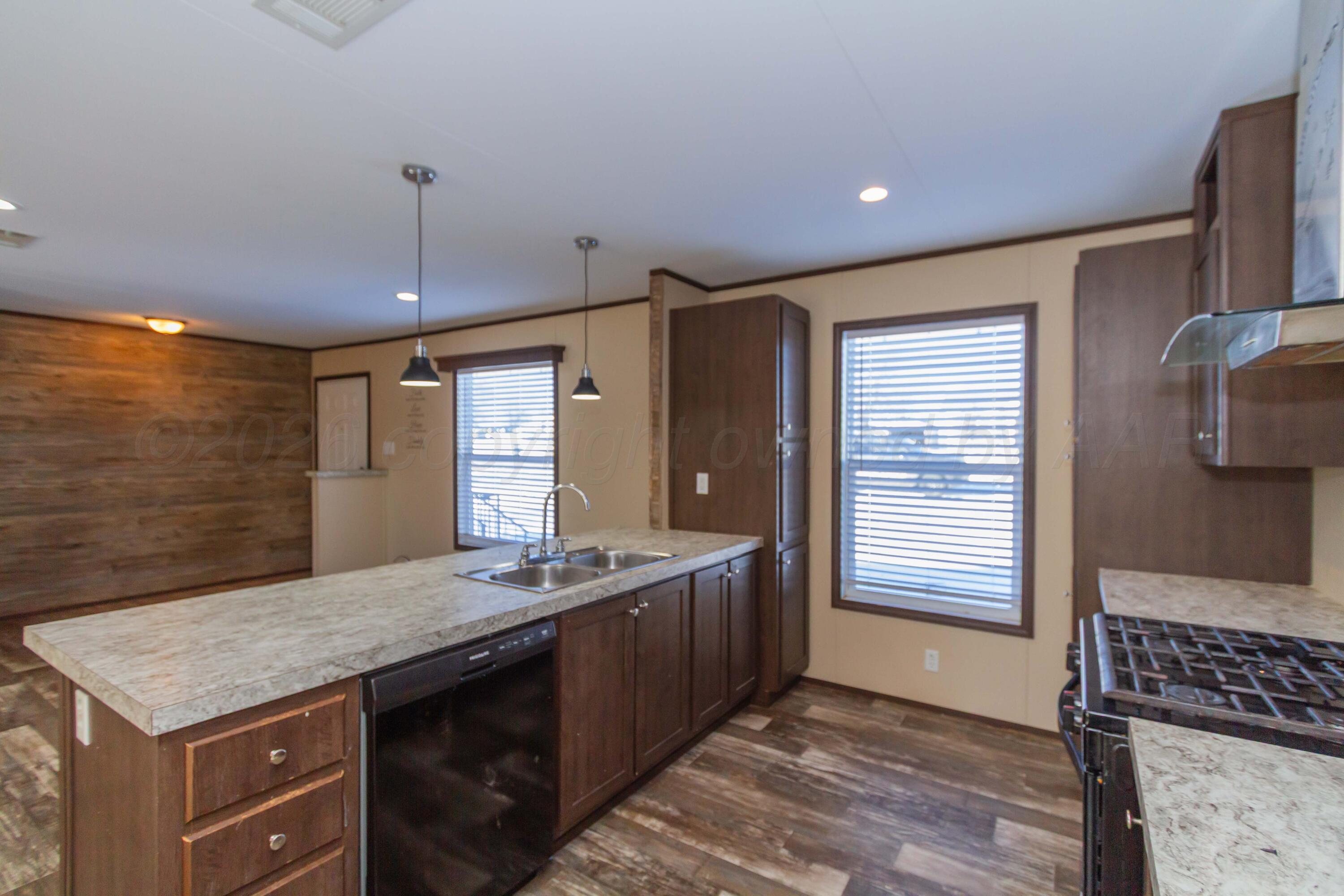 108 North Canadian Street Wheeler, TX 79096 - Photo 9 of 42 a kitchen with granite countertop a sink stainless steel appliances and cabinets