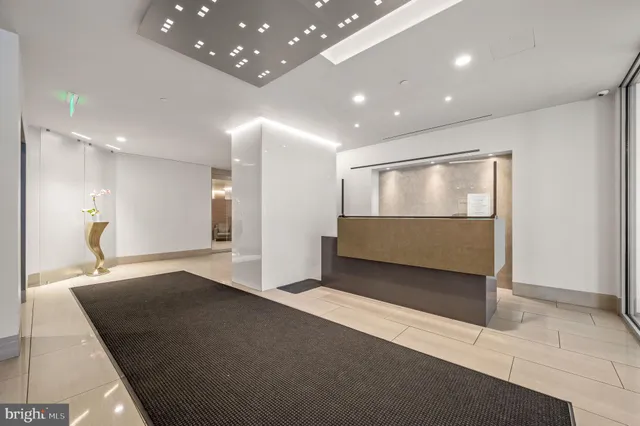 a view of an empty room with wooden floor and a bathroom