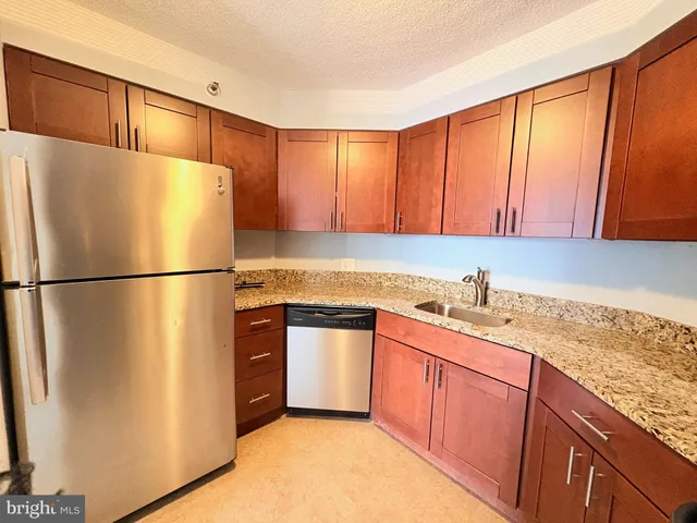 a kitchen with stainless steel appliances granite countertop a refrigerator sink and cabinets