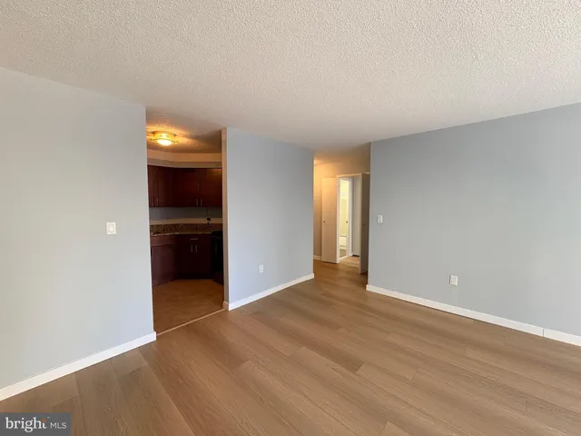 an empty room with wooden floor and entrance door