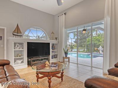 4050 Stoney Point Road Melbourne, FL 32940 - Photo 20 of 52 a living room with furniture a flat screen tv and a floor to ceiling window