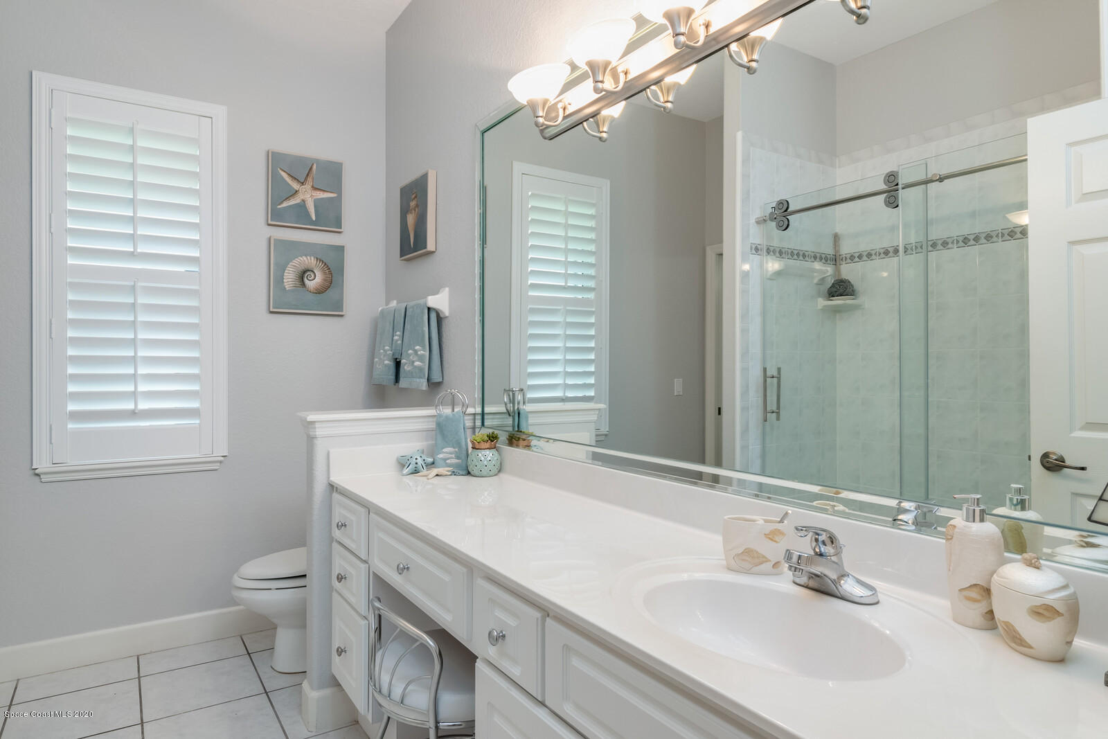 4050 Stoney Point Road Melbourne, FL 32940 - Photo 31 of 52 a bathroom with a granite countertop sink a toilet and a mirror