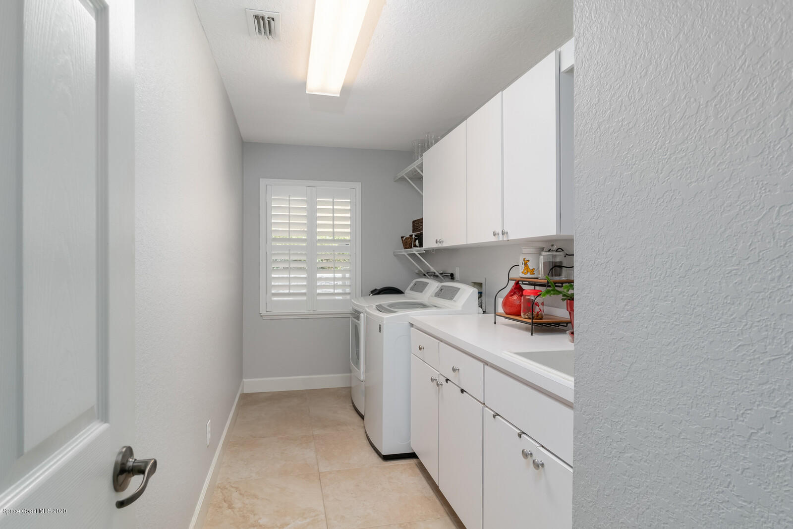 4050 Stoney Point Road Melbourne, FL 32940 - Photo 36 of 52 a kitchen with cabinets appliances a sink and a window