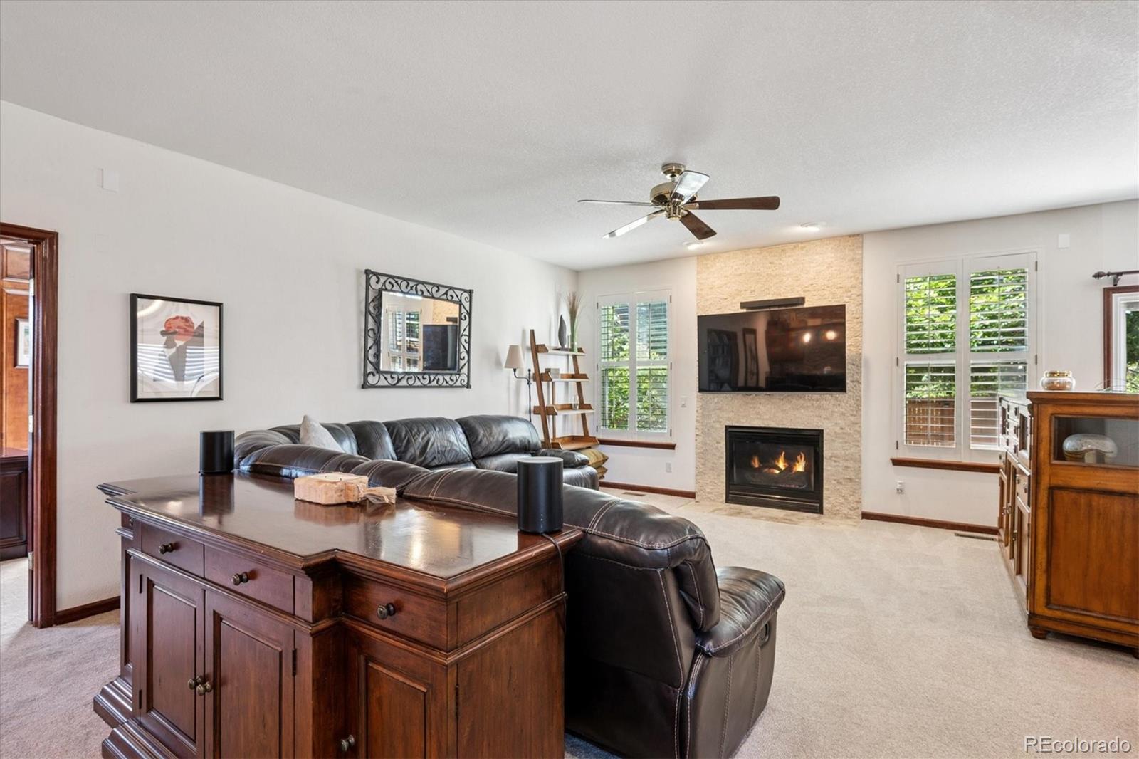 7804 Silverweed Way Lone Tree, CO 80124 - Photo 6 of 32 a living room with furniture a fireplace and a flat screen tv