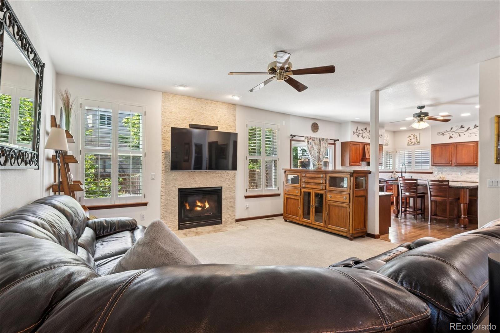 7804 Silverweed Way Lone Tree, CO 80124 - Photo 7 of 32 a living room with furniture a fireplace and a flat screen tv