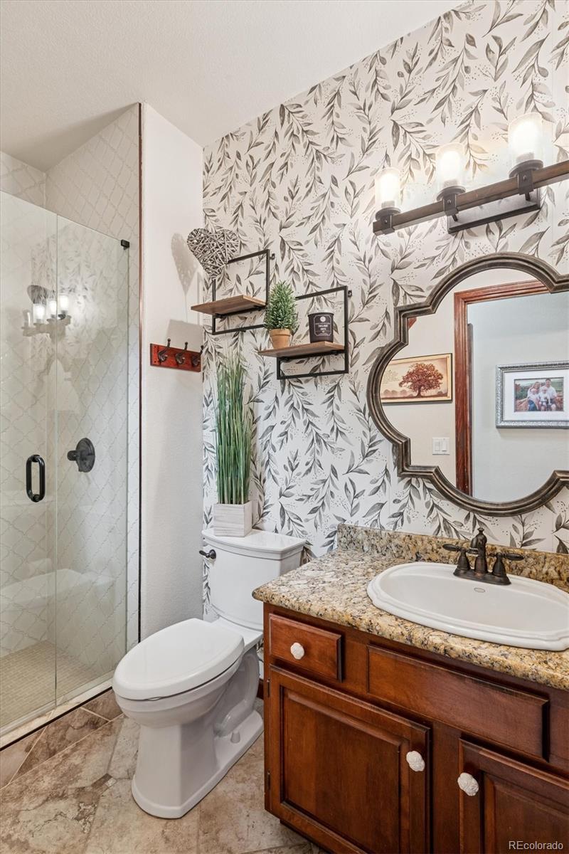 7804 Silverweed Way Lone Tree, CO 80124 - Photo 8 of 32 a bathroom with a granite countertop sink a toilet and shower