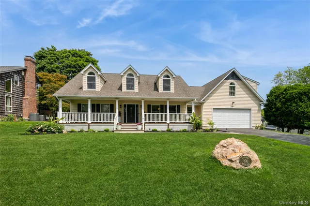 a front view of a house with a garden and trees