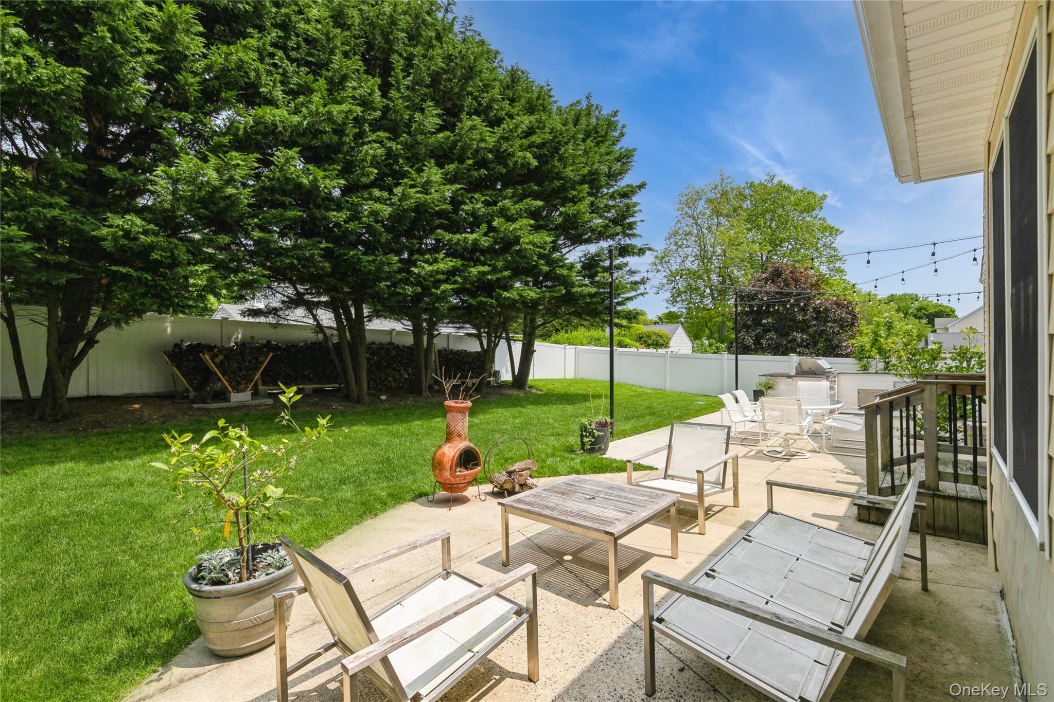 800 Ruth Road Mattituck, NY 11952 - Photo 27 of 29 a view of a patio with table and chairs potted plants and a large tree