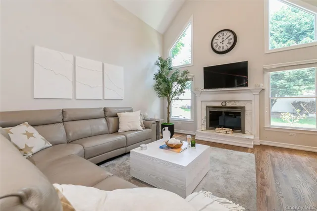a living room with furniture a large window and a fireplace