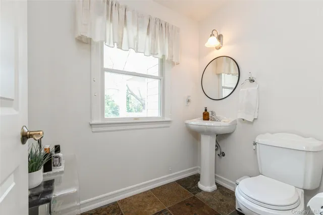 a bathroom with a toilet a sink and a mirror