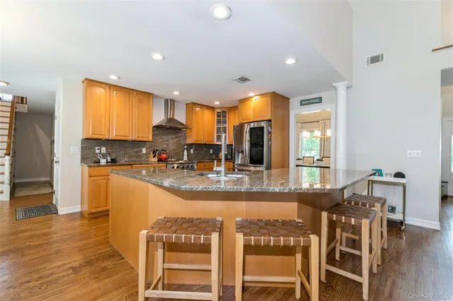 a kitchen with stainless steel appliances granite countertop dining table chairs and wooden floor