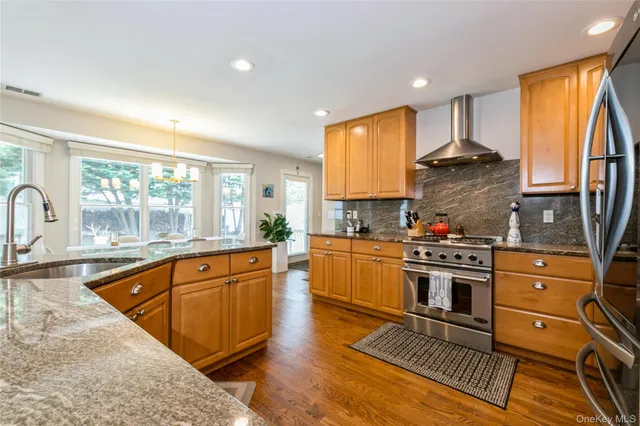 a kitchen with stainless steel appliances granite countertop a stove a sink and a refrigerator