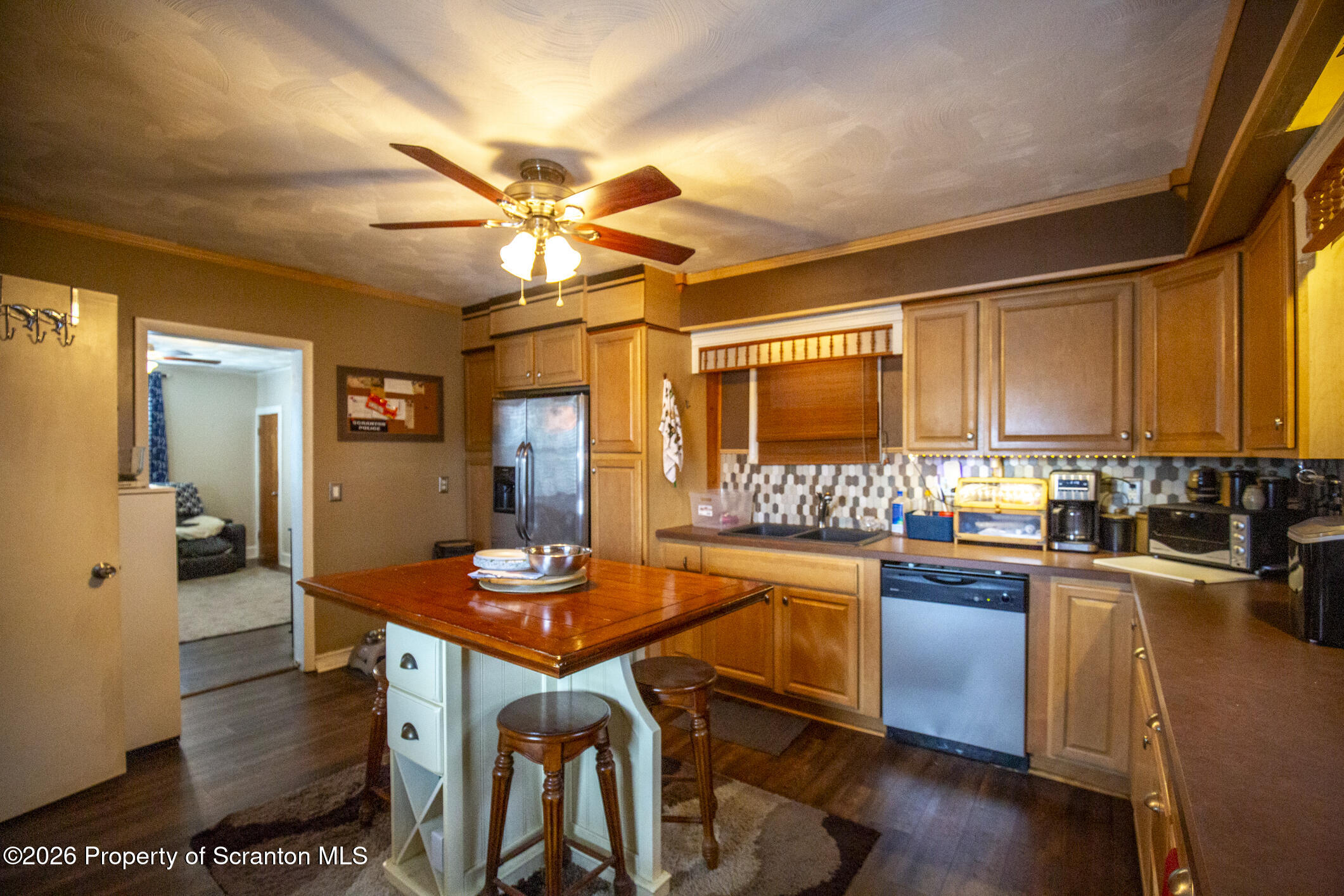 3245 Cedar Avenue Scranton, PA 18505 - Photo 21 of 37 a kitchen with stainless steel appliances granite countertop a stove a refrigerator a sink a dining table and chairs with wooden floor