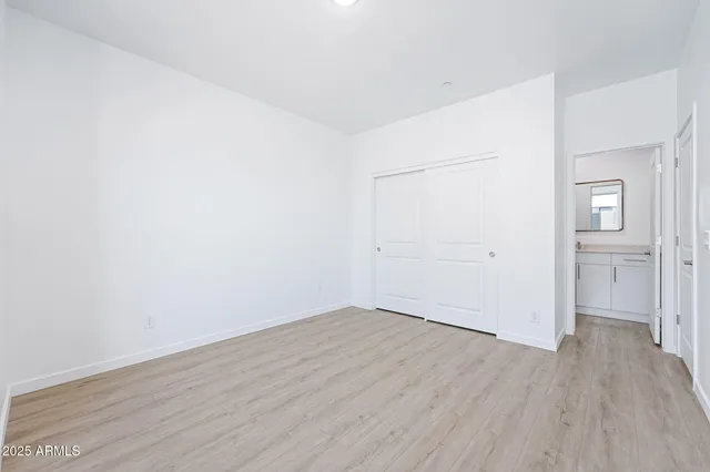 an empty room with wooden floor and natural light