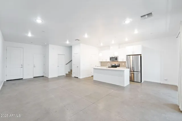a kitchen with a sink dishwasher and a refrigerator with wooden floor