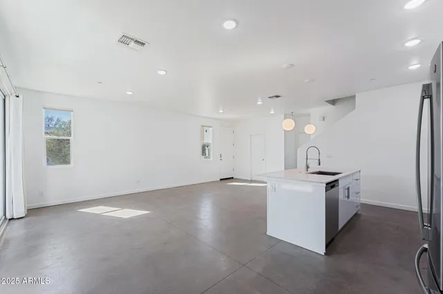 a kitchen with stainless steel appliances a refrigerator sink and microwave