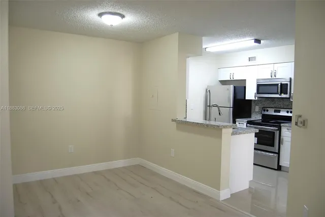 a room with stainless steel appliances a refrigerator and a stove top oven