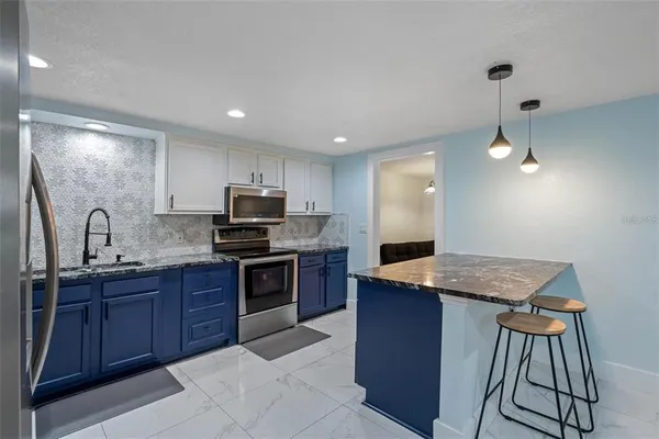 a kitchen with granite countertop stainless steel appliances and wooden cabinets