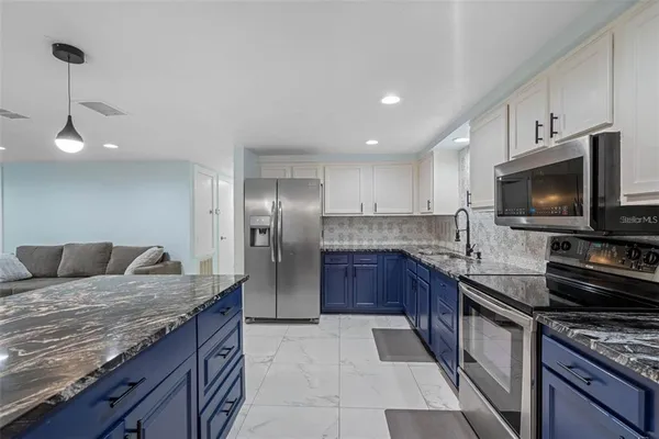 a kitchen with granite countertop a sink and stainless steel appliances