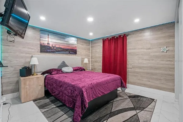 a bedroom with a bed and a flat screen tv