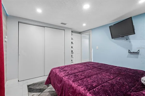 a bedroom with a bed and a flat screen tv