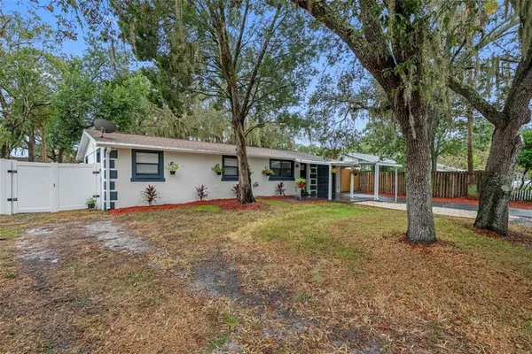 a view of a house with backyard and trees
