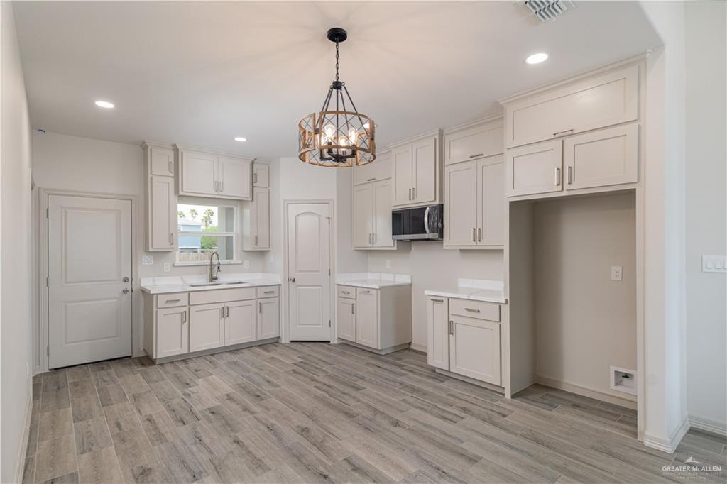 2118 Trinity Street Donna, TX 78537 - Photo 3 of 13 a kitchen with white cabinets stainless steel appliances and kitchen island
