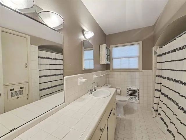 a bathroom with a sink a toilet and mirror