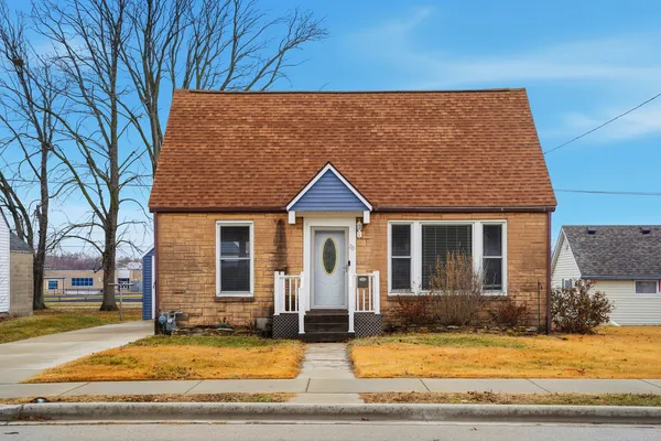 a view of a house with yard and large tree
