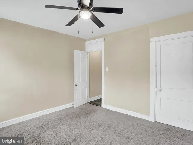 an empty room with chandelier fan