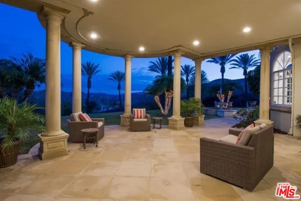 a living room with furniture and potted plants