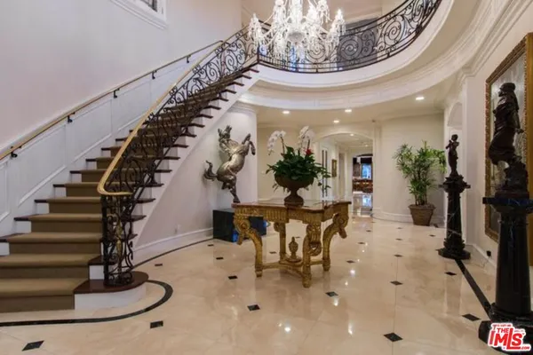 a view of hall way with furniture and a chandelier
