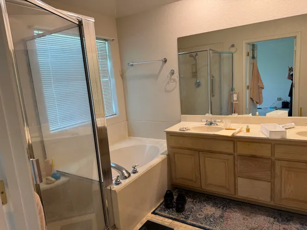 a bathroom with a tub sink and mirror