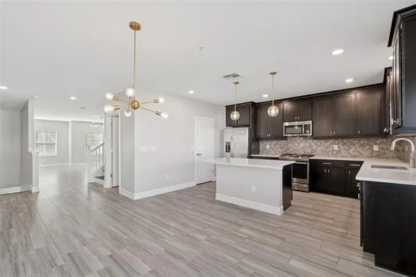 a kitchen with stainless steel appliances granite countertop refrigerator a sink a stove and cabinets